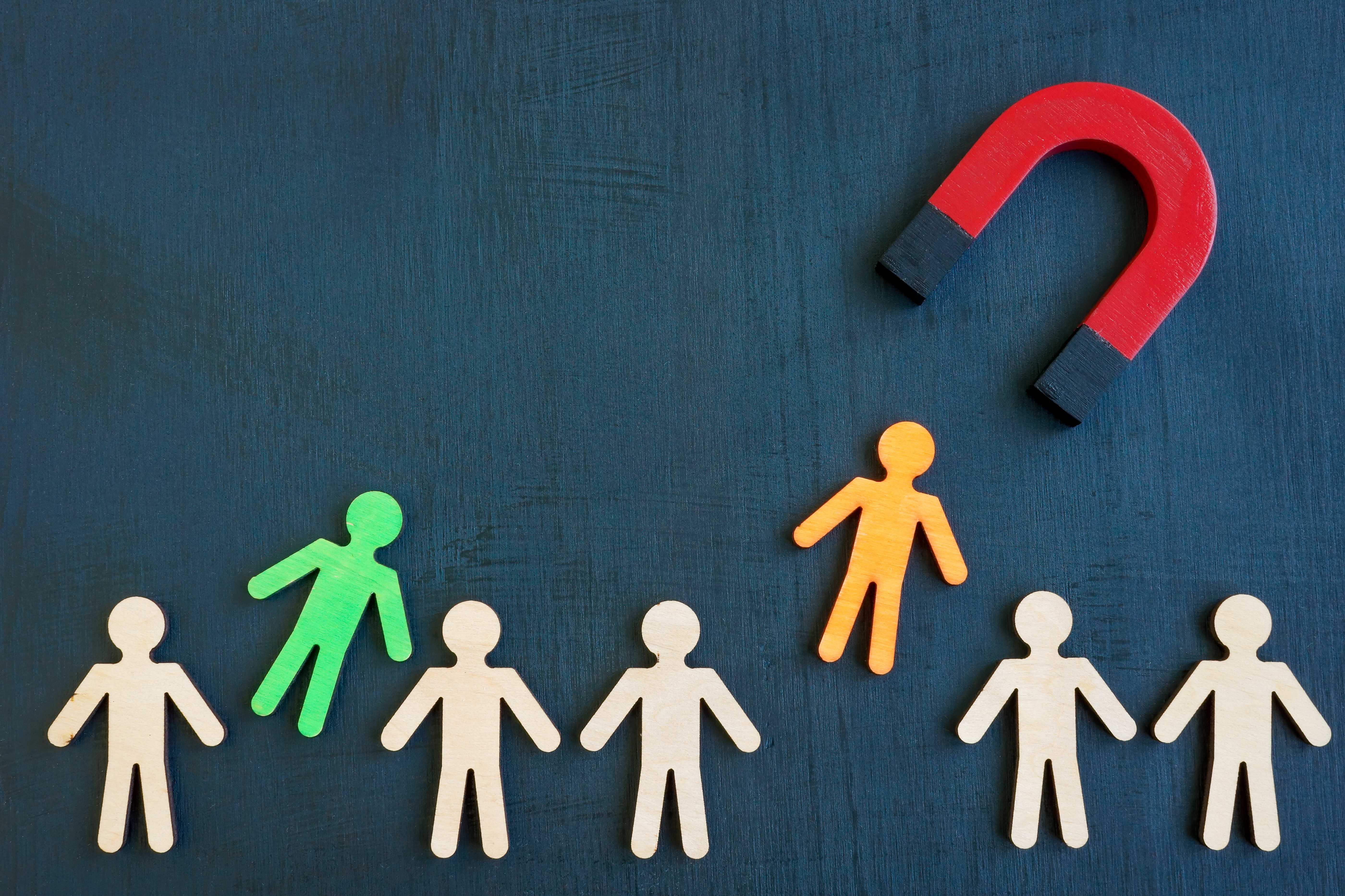 A large magnet attracting a specific person figure, symbolizing targeted recruiting.